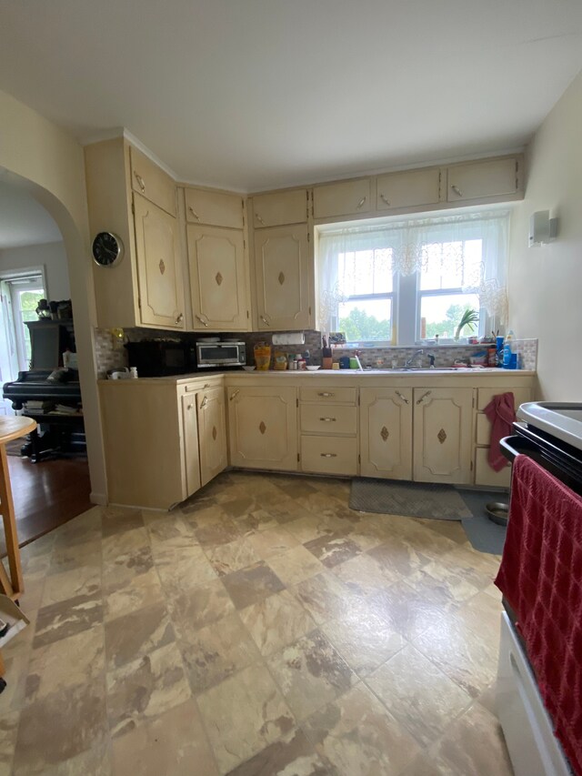 102 Jean St, Yale, MI 48097 - kitchen with cream cabinets, arched walkways, healthy amount of natural light, and tasteful backsplash