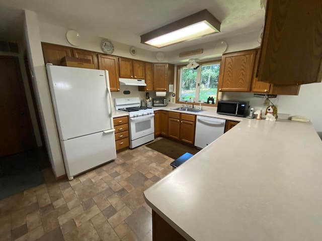 kitchen featuring kitchen peninsula, sink, and white appliances