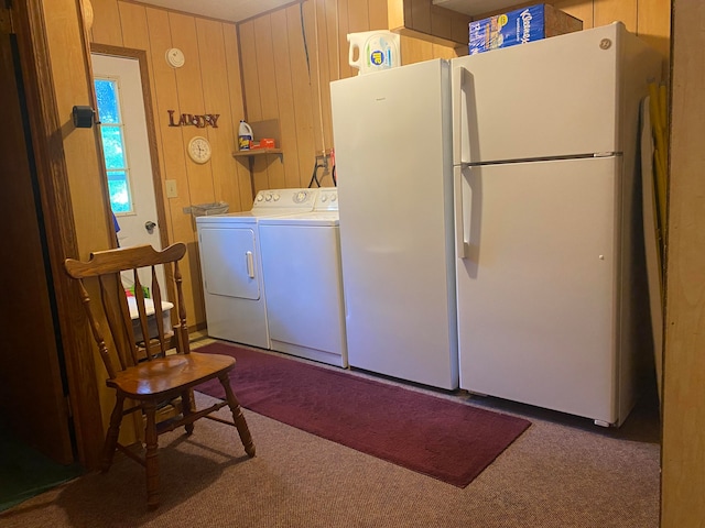 laundry room with carpet floors, washer and clothes dryer, and wooden walls