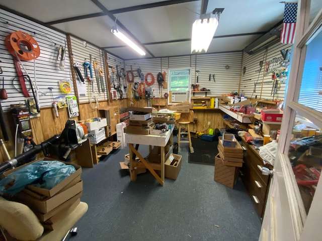 misc room with a workshop area and wooden walls