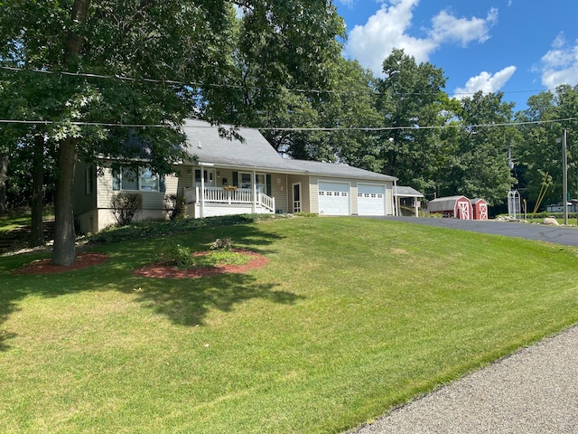 single story home featuring a garage, a porch, and a front yard