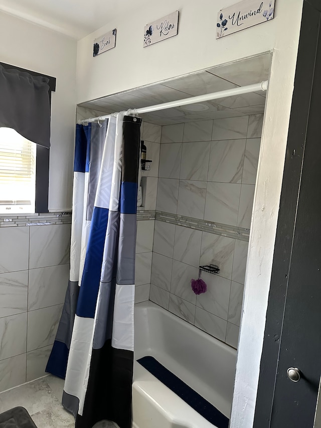 bathroom featuring tile walls and shower / bath combo