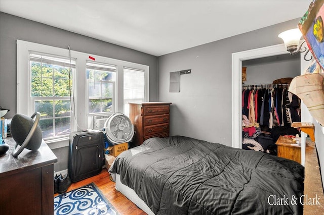 bedroom featuring light hardwood / wood-style floors, a closet, and cooling unit