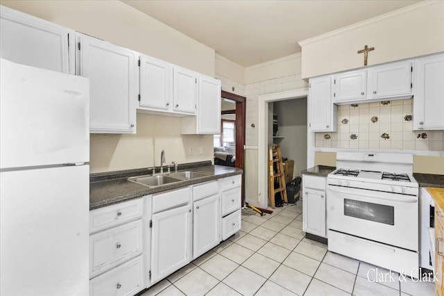 kitchen featuring white appliances, crown molding, sink, light tile patterned floors, and white cabinets