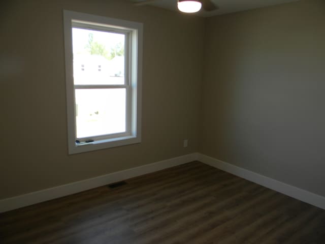 unfurnished room featuring dark hardwood / wood-style flooring and ceiling fan