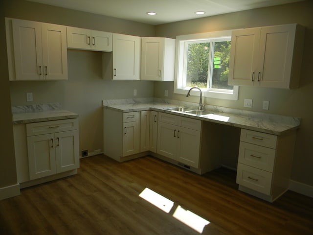 kitchen featuring white cabinets, dark hardwood / wood-style floors, light stone countertops, and sink