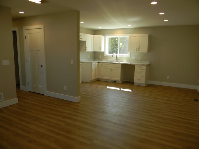 kitchen featuring sink, white cabinetry, and dark wood-type flooring