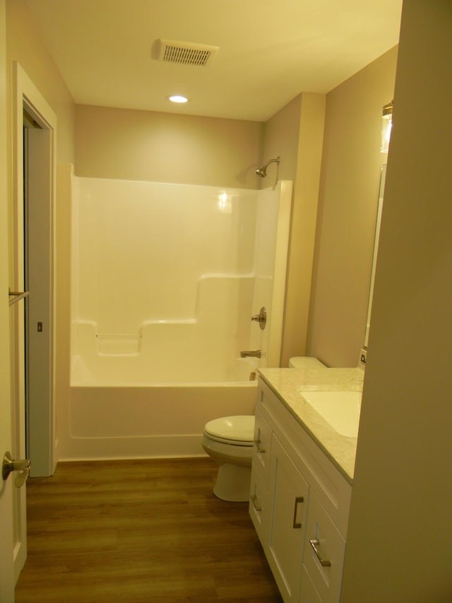 full bathroom with shower / tub combination, toilet, vanity, and hardwood / wood-style flooring