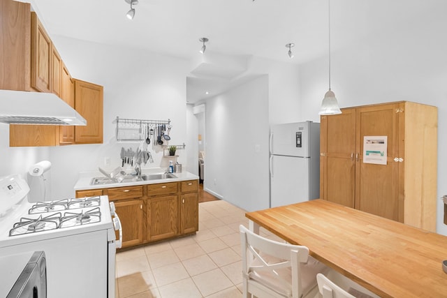 kitchen featuring pendant lighting, white appliances, light tile patterned floors, and sink