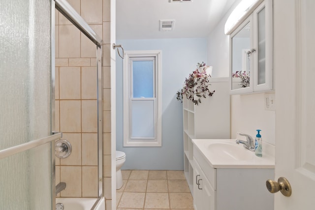 full bathroom featuring toilet, vanity, tile patterned floors, and bath / shower combo with glass door