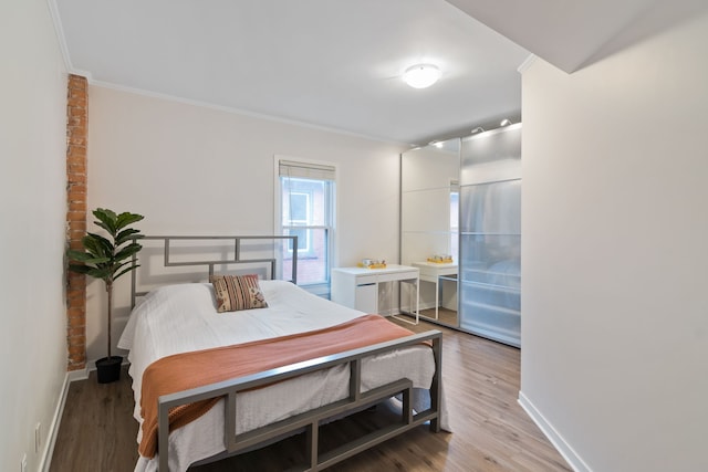 bedroom with hardwood / wood-style floors and ornamental molding