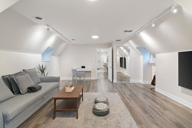 living room with lofted ceiling, light hardwood / wood-style flooring, and track lighting