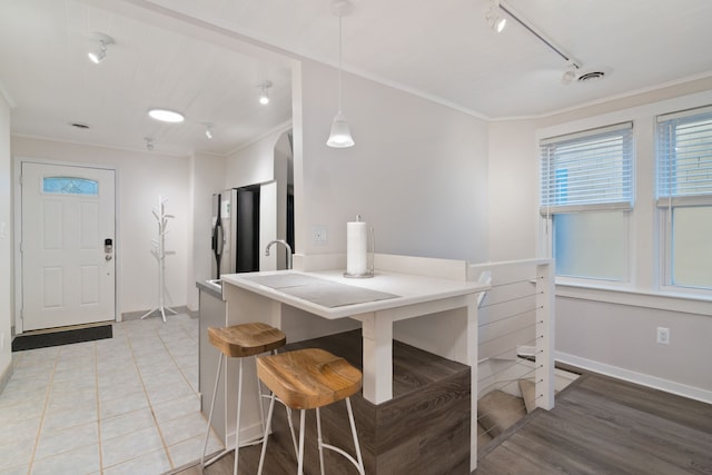 dining room with track lighting, light hardwood / wood-style flooring, and ornamental molding