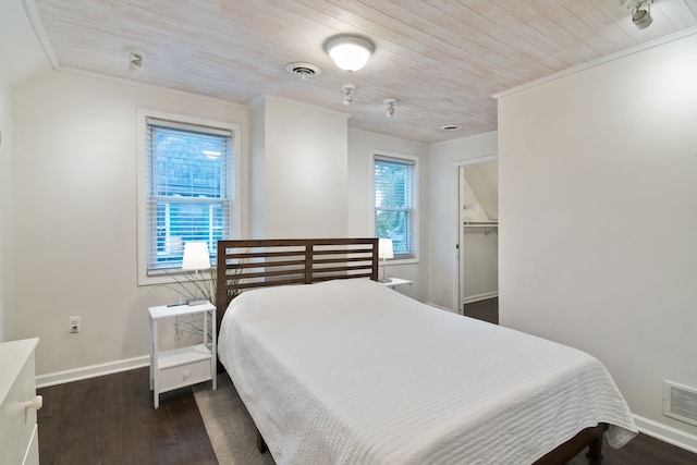 bedroom with wooden ceiling, dark wood-type flooring, a walk in closet, ornamental molding, and a closet