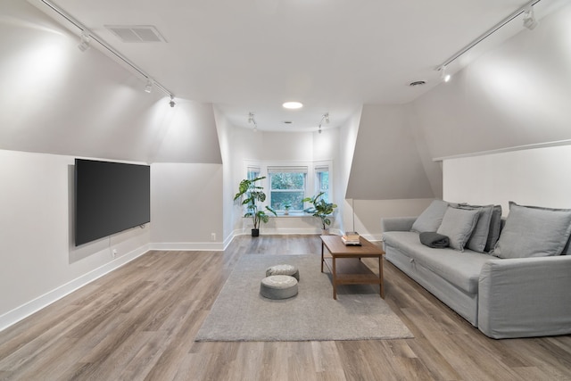 living room with lofted ceiling, light hardwood / wood-style flooring, and track lighting