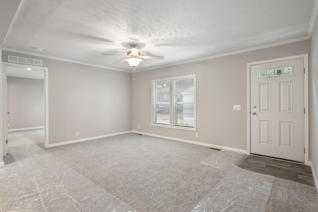 foyer with carpet flooring, ornamental molding, a textured ceiling, and a wealth of natural light