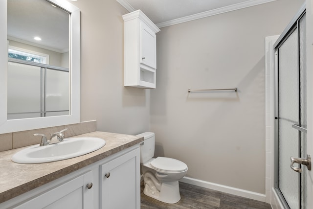 bathroom with hardwood / wood-style floors, vanity, crown molding, toilet, and an enclosed shower