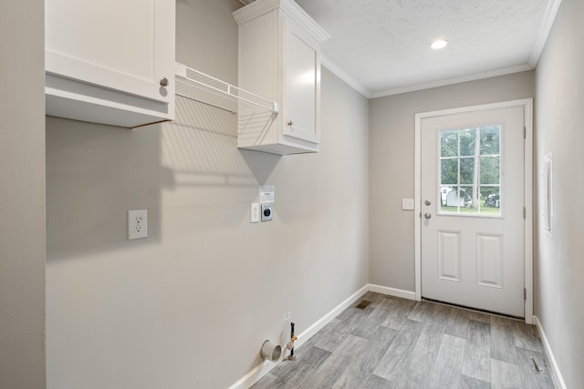 laundry room with cabinets, ornamental molding, light wood-type flooring, and hookup for an electric dryer