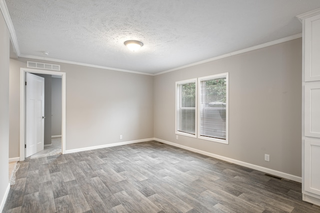 empty room featuring a textured ceiling, wood-type flooring, and ornamental molding