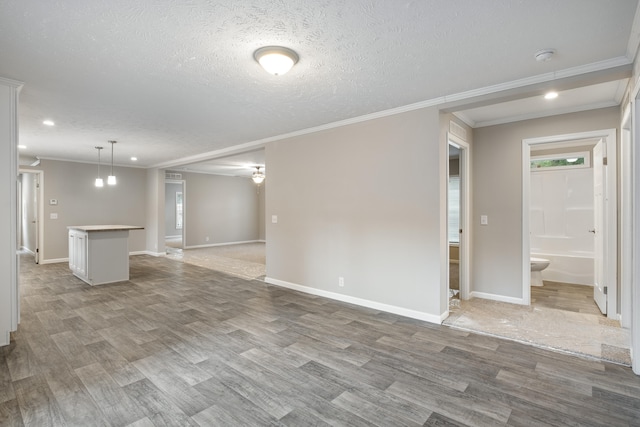 unfurnished living room featuring hardwood / wood-style floors, a textured ceiling, and crown molding