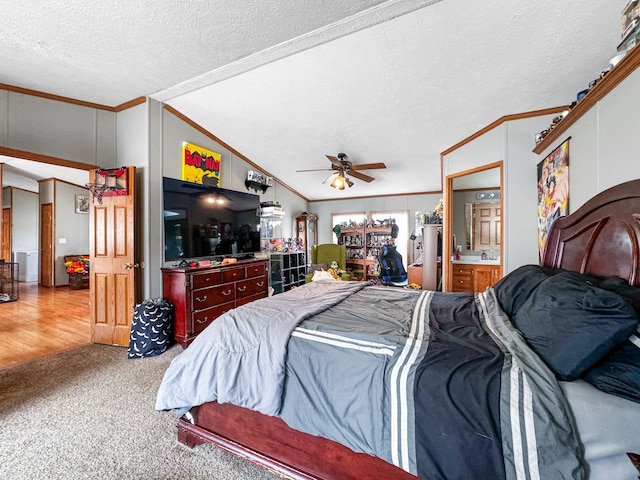 bedroom featuring a textured ceiling, connected bathroom, vaulted ceiling, and ceiling fan