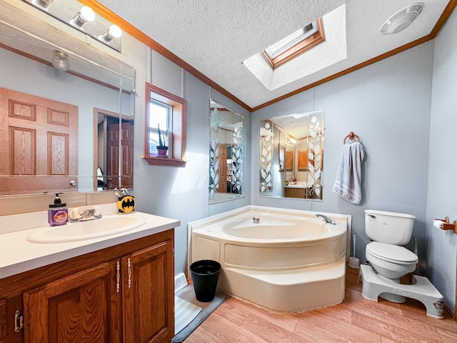 bathroom featuring vaulted ceiling with skylight, a washtub, a textured ceiling, and hardwood / wood-style flooring