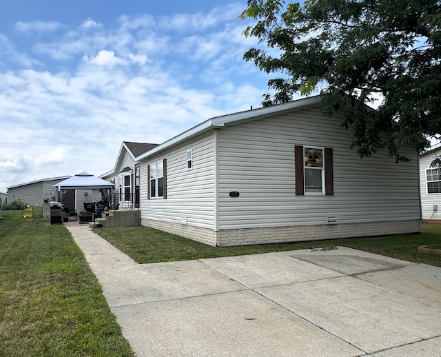 view of side of home featuring a gazebo and a yard