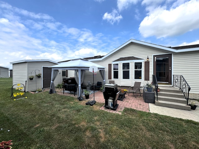 back of house with a gazebo, a storage shed, a yard, and a patio