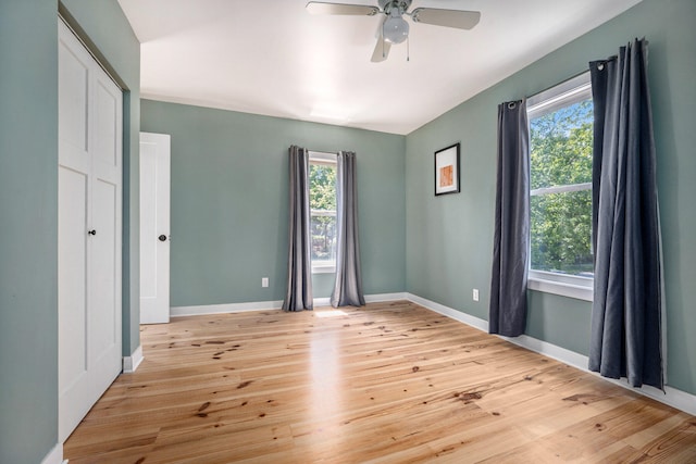 unfurnished room featuring ceiling fan, a healthy amount of sunlight, and light wood-type flooring