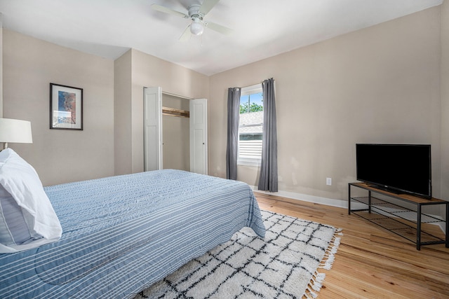 bedroom featuring ceiling fan, a closet, and hardwood / wood-style flooring