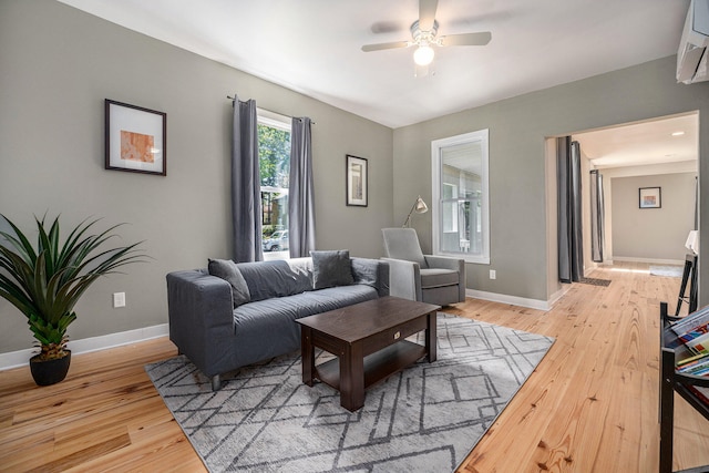 living room with ceiling fan, wood-type flooring, and a wall mounted AC