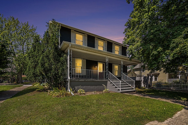 view of front facade featuring covered porch and a yard