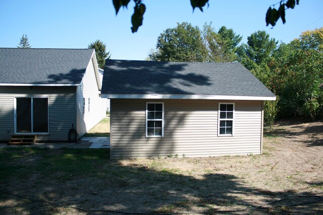2960 W John Beers Rd, Stevensville, MI 49127 - view of side of home featuring entry steps, a shingled roof, and a yard