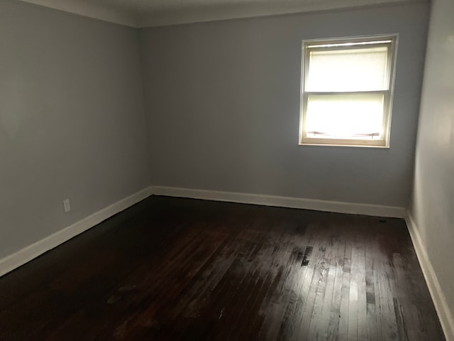 unfurnished room with dark wood-type flooring