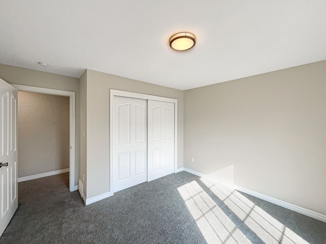 unfurnished bedroom with a closet and dark colored carpet