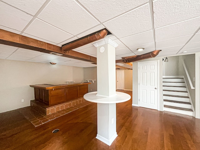 bar featuring a drop ceiling and dark hardwood / wood-style flooring