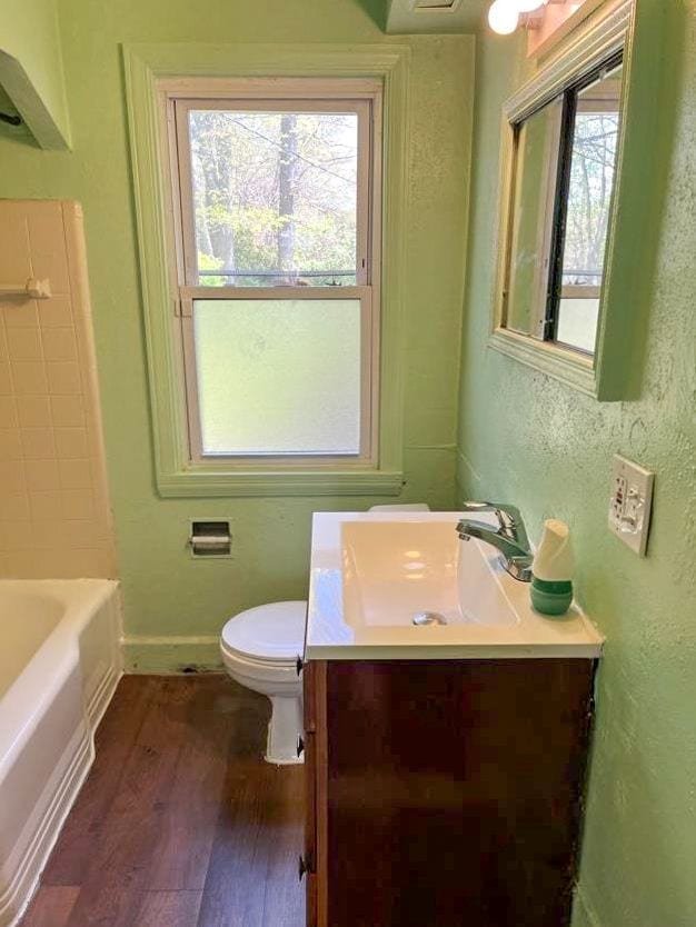 bathroom with hardwood / wood-style floors, vanity, toilet, and plenty of natural light