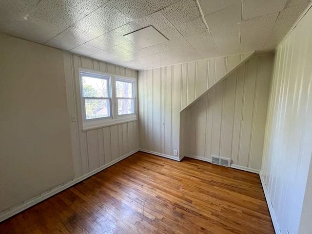 spare room with wood walls and hardwood / wood-style floors