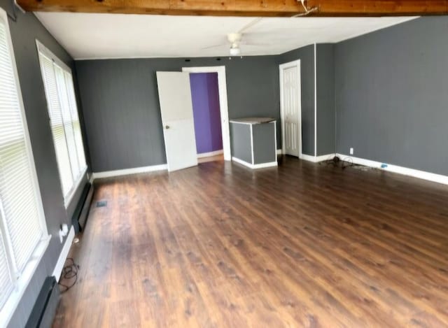 spare room with beamed ceiling, dark hardwood / wood-style flooring, ceiling fan, and a baseboard heating unit