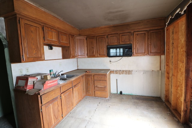 4318 Tommy Armour Dr, Flint, MI 48506 - kitchen featuring a sink, black microwave, brown cabinets, and concrete floors