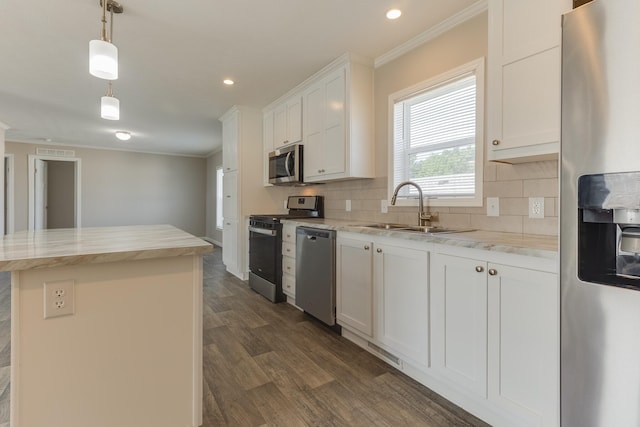 kitchen featuring dark hardwood / wood-style flooring, stainless steel appliances, sink, pendant lighting, and white cabinets