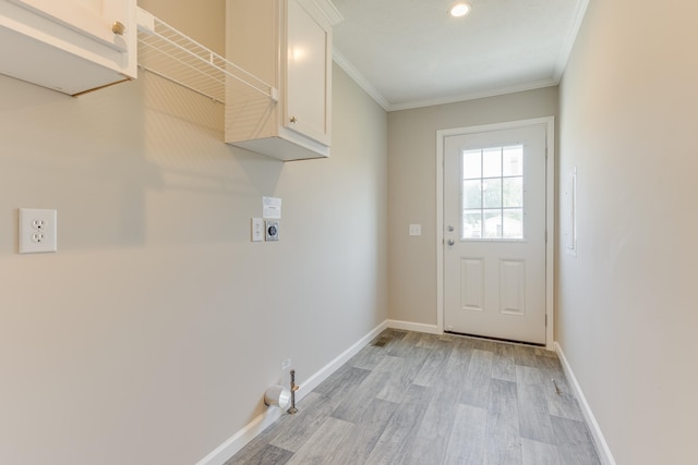 clothes washing area featuring cabinets, hookup for an electric dryer, crown molding, and light hardwood / wood-style floors