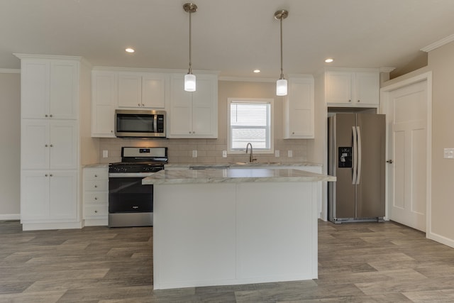 kitchen with crown molding, white cabinetry, pendant lighting, and stainless steel appliances