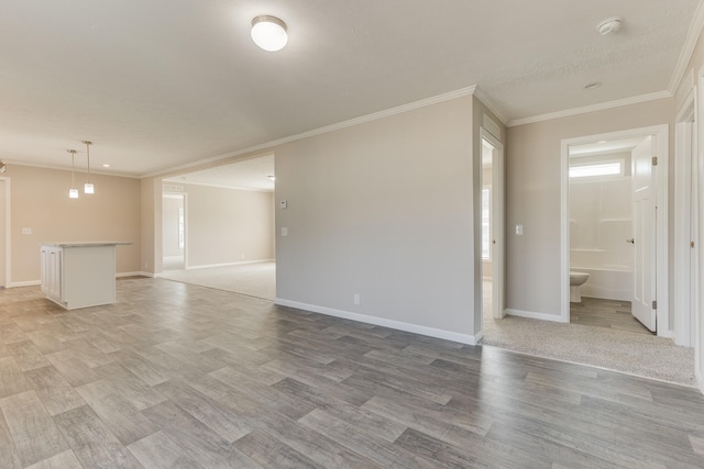 empty room featuring light wood-type flooring and ornamental molding