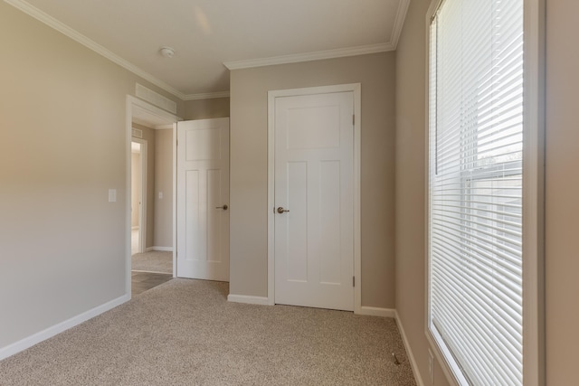 unfurnished bedroom with light colored carpet, a closet, and ornamental molding