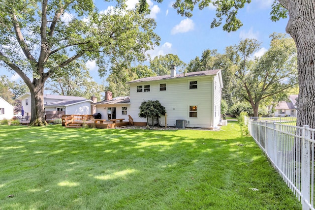 back of house featuring central AC, a yard, and a deck
