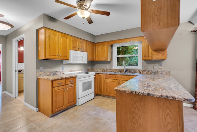 kitchen featuring white appliances, sink, ceiling fan, light stone counters, and kitchen peninsula