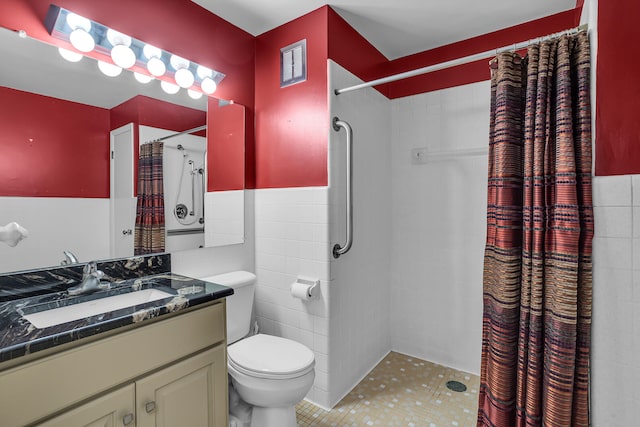 bathroom with vanity, tile walls, tile patterned flooring, toilet, and curtained shower