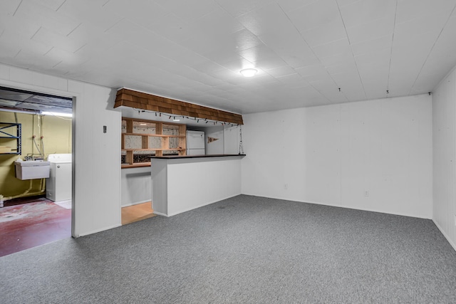 basement with carpet flooring, sink, and washer / dryer