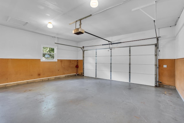 garage with a garage door opener and wood walls